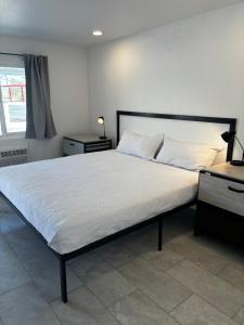 1 dormitorio con 1 cama grande con sábanas blancas en Boulder City Inn en Boulder City