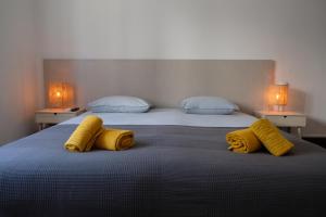 2 camas con mantas amarillas y almohadas en Yellow Inn Aveiro en Aveiro