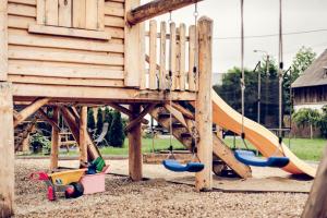 a wooden playground with a slide in front of a building at Willa Nad Potokiem in Czarny Dunajec