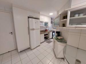 uma cozinha branca com um frigorífico e um balcão em Cobertura ideal pra família toda! no Rio de Janeiro