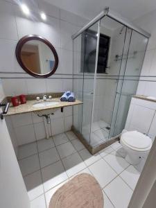 uma casa de banho com um chuveiro, um WC e um espelho. em Cobertura ideal pra família toda! no Rio de Janeiro