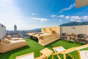 a rooftop patio with a hot tub and grass at Sky Wave Patong in Patong Beach