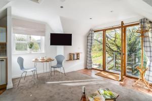 a living room with a table and chairs and a window at The Loft in Mickleton