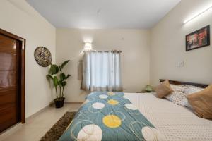 a bedroom with a bed with a colorful blanket at House of 2 Tress Penthouse in Bangalore