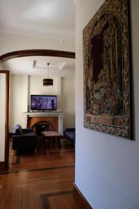 a living room with a fireplace and a painting on the wall at Yellow Inn Aveiro in Aveiro