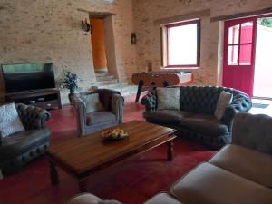 a living room with couches and a coffee table at Gite La Minoterie - Piscine & spa 