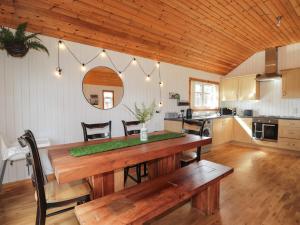 a kitchen and dining room with a wooden table at Chalet C in Dornoch