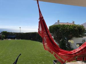 a red hammock hanging from the side of a house at Ericeira Su Villa`s in Ericeira
