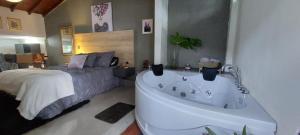 a bedroom with a bed and a tub next to a bed at Luxury Loft Shakespeare in Medellín