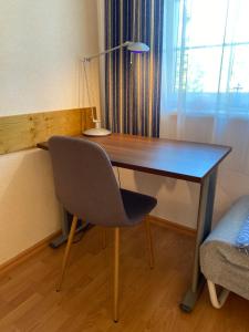 a desk with a chair and a lamp in a room at Útulná izba v dome pod lesom in Bojnice