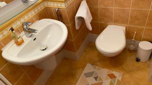 łazienka z białą umywalką i toaletą w obiekcie Útulná izba v dome pod lesom w mieście Bojnice