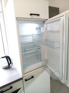 una nevera vacía con la puerta abierta en una cocina en Family Apartment With kitchen Neunkirchen en Neunkirchen