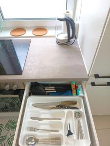 un cajón en una nevera abierta llena de utensilios en Family Apartment With kitchen Neunkirchen en Neunkirchen