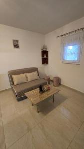 Una sala de estar con un sofá y una mesa de café. en Apartmani Plavšić, en Novi Vinodolski
