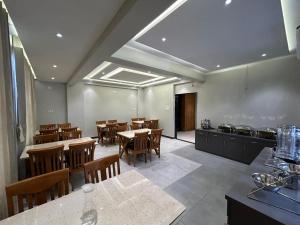 a dining room with tables and chairs and a kitchen at Hotel Holiday Icon in Dwarka
