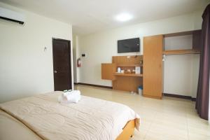 1 dormitorio con 1 cama y TV de pantalla plana en LB Pietz Pension House, en Cordova