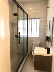 a bathroom with a shower and a toilet and a sink at Portland Residence in Lekki