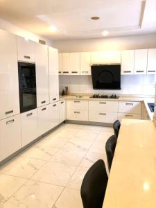 a kitchen with white cabinets and a table with chairs at Portland Residence in Lekki