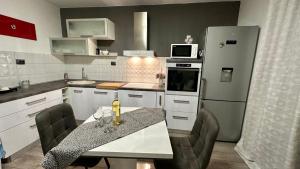 a kitchen with a table and a refrigerator at Apartment Lučka II in Banjol +11 photos