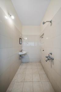 a white bathroom with a sink and a toilet at House of 2 Tress Penthouse in Bangalore