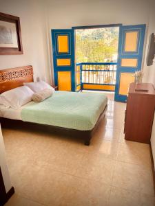 a bedroom with a bed and a balcony at Hospedaje Camino Real a 150 MTS del centro in Salento