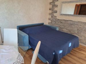a blue bed in a room with a mirror at Verdemare in Duino