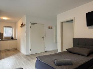 OTTO Apartments في هامبورغ: غرفة نوم بسرير ومطبخ مع تلفزيون