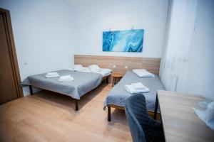 a room with two beds and a table at Staryi Krakiv in Lviv