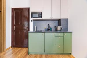 una cocina con armarios verdes y una puerta en Kojak, en Jastrzębia Góra