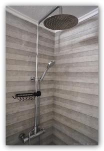 a shower with a shower head in a bathroom at Lido by Welcome Home in Ermoupoli