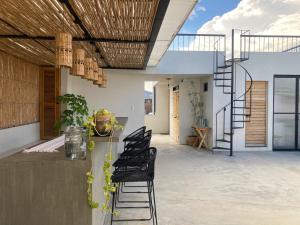 瓦哈卡市Casa 821 Guest House的带黑色椅子和螺旋楼梯的露台