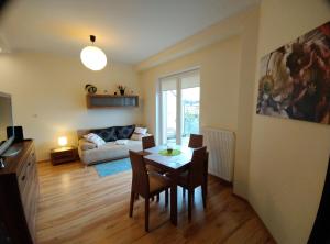 ein Wohnzimmer mit einem Tisch, Stühlen und einem Sofa in der Unterkunft Apartament Gardena II Olsztyn Jaroty in Olsztyn