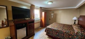 a hotel room with a bed and a flat screen tv at Town House Inn and Suites in Elmwood Park +15 photos