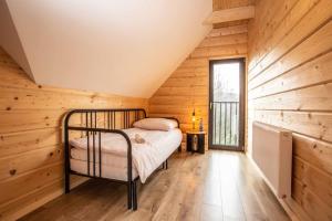 a bedroom in a log cabin with a bed at Gorczański dom z bali w górach in Poręba Wielka