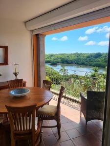 a dining room with a table and a view of a river at Casa in Terre Rouge