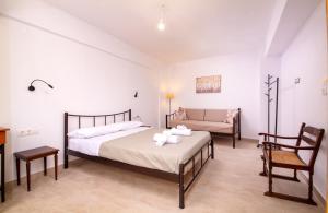 a bedroom with a bed and a chair and a couch at Traditional Anna's Stone House with Private Pool in Margarítai
