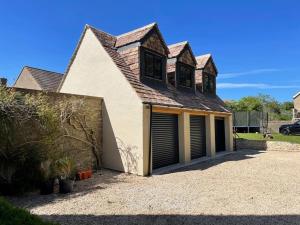 a large white house with a large garage at Cotswold self-catering apartment in Cirencester