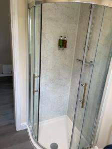 y baño con ducha y puerta de cristal. en Cotswold self-catering apartment en Cirencester