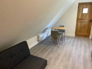 Habitación con sofá y mesa con sillas. en Cotswold self-catering apartment en Cirencester