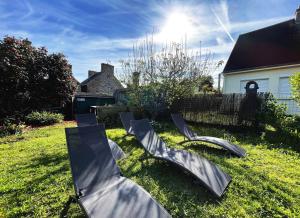 a group of chairs sitting in the grass in a yard at Maison Kérity with Jacuzzi – Terrace in Paimpol