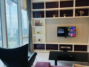 a living room with a tv on a wall at The Platinum KLCC By Staycation in Kuala Lumpur