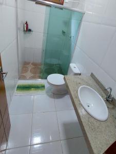 a bathroom with a toilet and a sink and a shower at Casa Mobiliada para o período do Festival Folclórico de Parintins 2024 in Parintins +2 photos