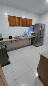 a kitchen with a sink and a refrigerator at Casa Mobiliada para o período do Festival Folclórico de Parintins 2024 in Parintins
