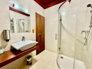 a bathroom with a sink and a shower at Tatragolf Resort Apartment I206 Tatranská Lomnica in Veľká Lomnica +7 photos