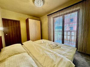 a bedroom with a bed and a large window at Tatragolf Resort Apartment I206 Tatranská Lomnica in Veľká Lomnica