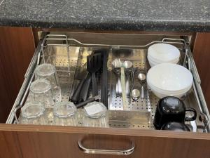 a drawer in a cabinet filled with utensils at Maple Grove Traditional Homes. in Bangalore
