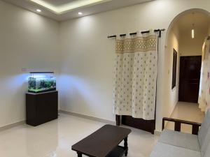 a living room with a curtain and a fish tank at Maple Grove Traditional Homes. in Bangalore