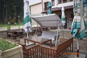 een tafel en stoelen met parasols en een tafel bij Villa Park Guest Apartments in Borovets