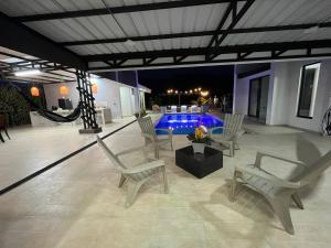 a patio with chairs and a pool at night at PALO ALTO - EXCLUSIVA CASA DE CAMPO in Restrepo