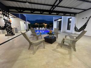 a patio with chairs and a table and a pool at PALO ALTO - EXCLUSIVA CASA DE CAMPO in Restrepo